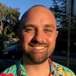 A color photo of a man smiling for a photo